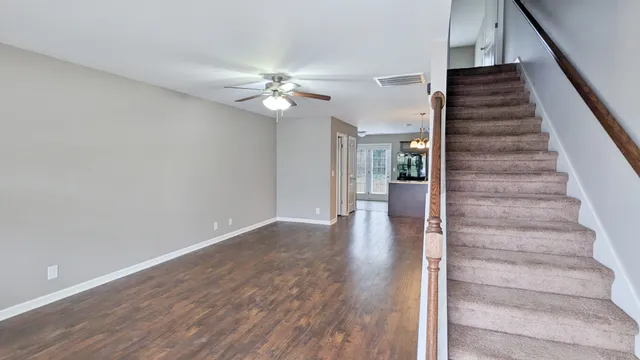 a view of an entryway with wooden floor and a ceiling fan