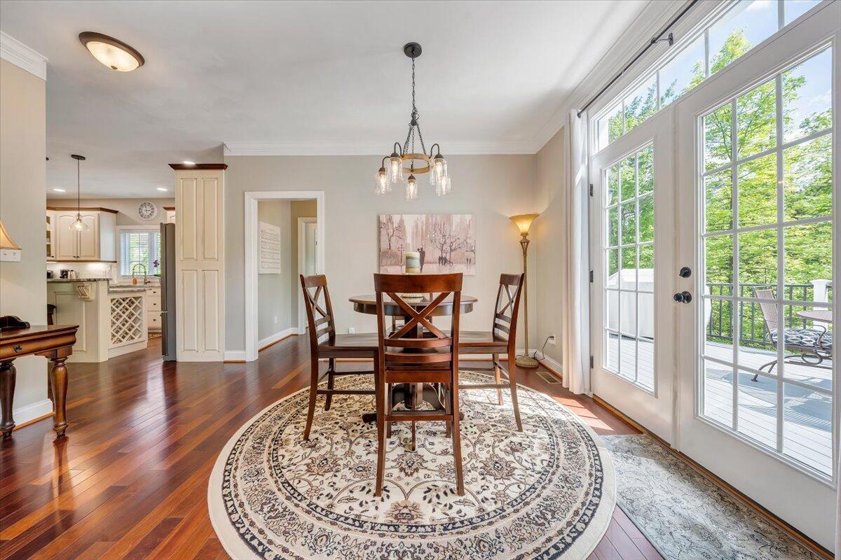 46 Claybrook Court Blue Ridge, VA 24064 - Photo 16 of 76 a dining room with wooden floor a chandelier a wooden table and chairs