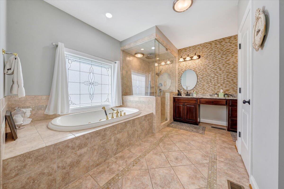 46 Claybrook Court Blue Ridge, VA 24064 - Photo 33 of 76 a spacious bathroom with a granite countertop double vanity sink a mirror and a bathtub