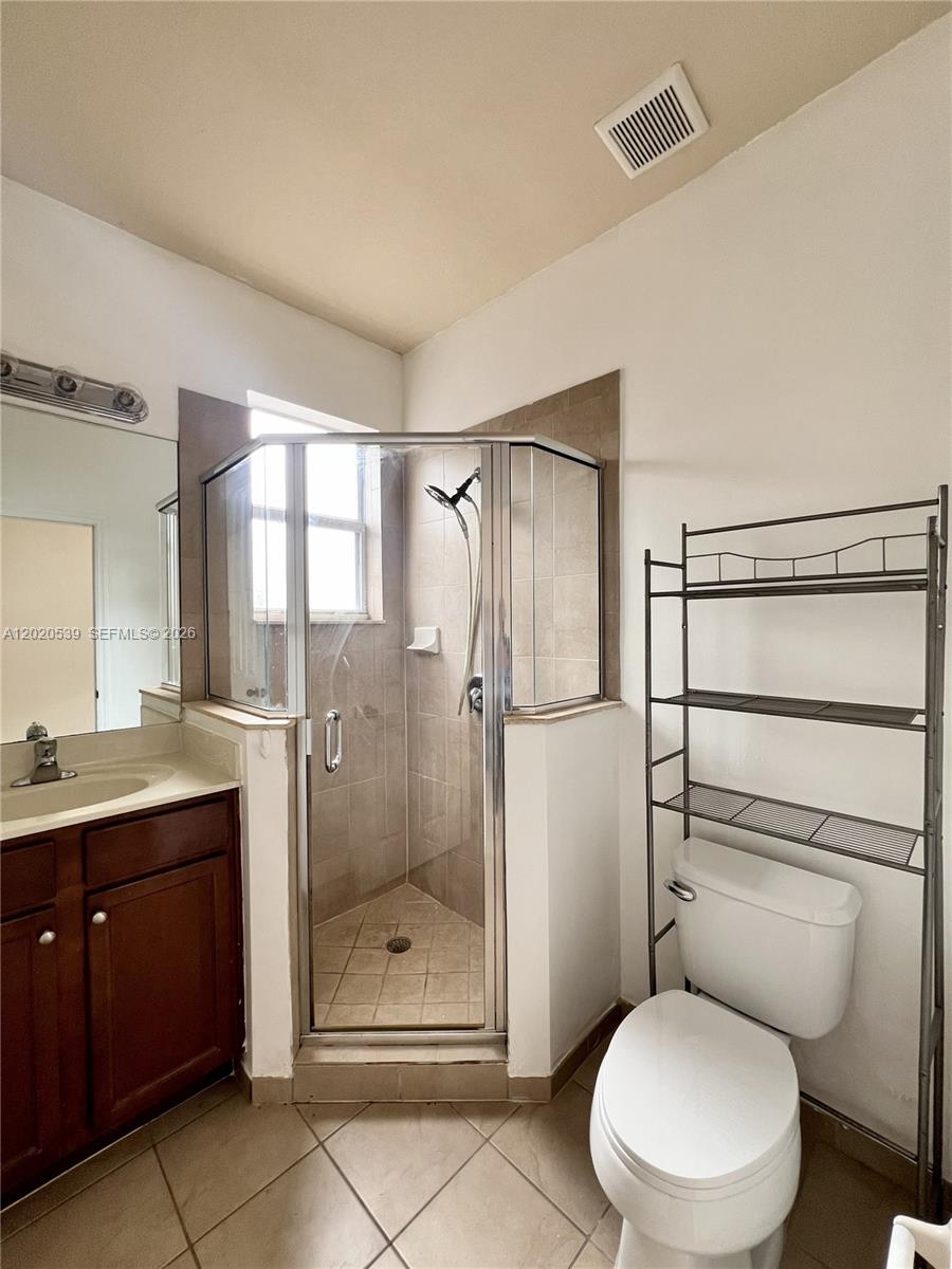 17001 Southwest 96th Street Miami, FL 33196 - Photo 22 of 23 a bathroom with a granite countertop toilet sink and shower
