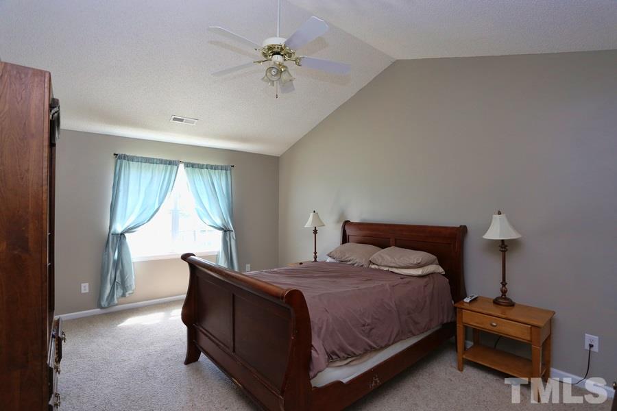 236 Hunters Farm Drive Raleigh, NC 27603 - Photo 12 of 21 a bedroom with a bed and a chandelier