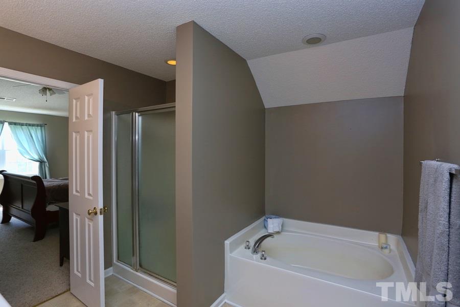 236 Hunters Farm Drive Raleigh, NC 27603 - Photo 13 of 21 a white bath tub sitting in a en suite bathroom