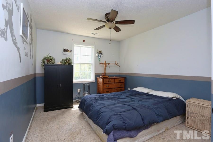 236 Hunters Farm Drive Raleigh, NC 27603 - Photo 15 of 21 a bedroom with a bed and wooden floor