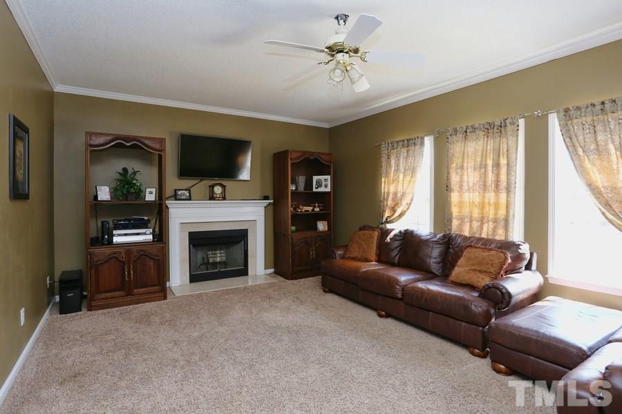 236 Hunters Farm Drive Raleigh, NC 27603 - Photo 4 of 21 a living room with furniture a fireplace and a flat screen tv
