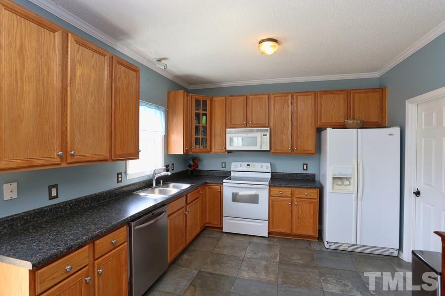 236 Hunters Farm Drive Raleigh, NC 27603 - Photo 6 of 21 a kitchen with stainless steel appliances granite countertop a stove a refrigerator a sink dishwasher and wooden cabinets
