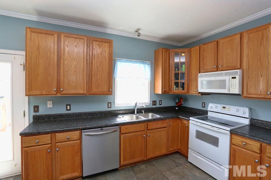 236 Hunters Farm Drive Raleigh, NC 27603 - Photo 7 of 21 a kitchen with granite countertop white cabinets sink and window