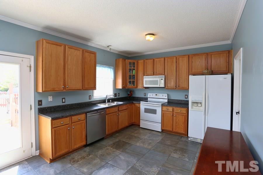 236 Hunters Farm Drive Raleigh, NC 27603 - Photo 8 of 21 a kitchen with granite countertop a stove top oven a sink dishwasher and a refrigerator