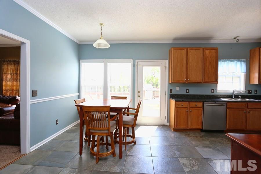 236 Hunters Farm Drive Raleigh, NC 27603 - Photo 10 of 21 a kitchen with stainless steel appliances granite countertop wooden cabinets a dining table and chairs