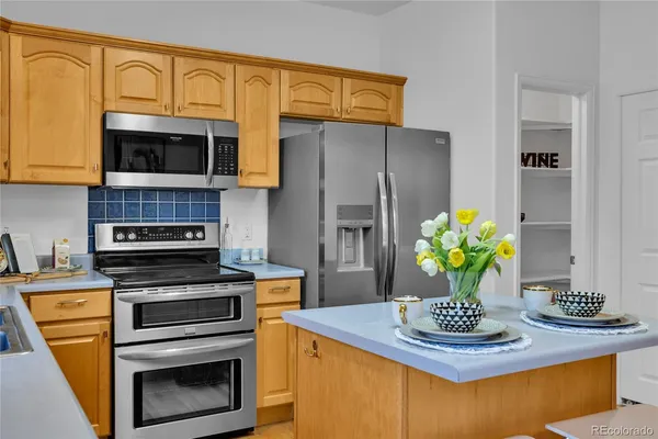 a kitchen with stainless steel appliances a stove refrigerator and microwave
