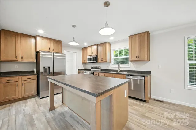 a kitchen with stainless steel appliances granite countertop a sink stove and refrigerator