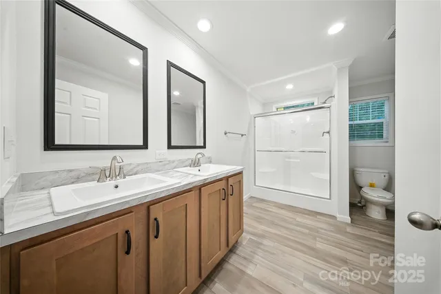 a bathroom with a sink a toilet and shower