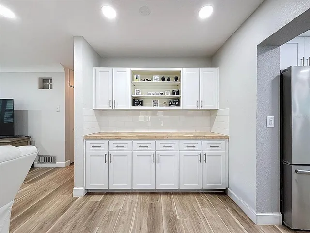 a kitchen with stainless steel appliances kitchen island a refrigerator sink and chairs