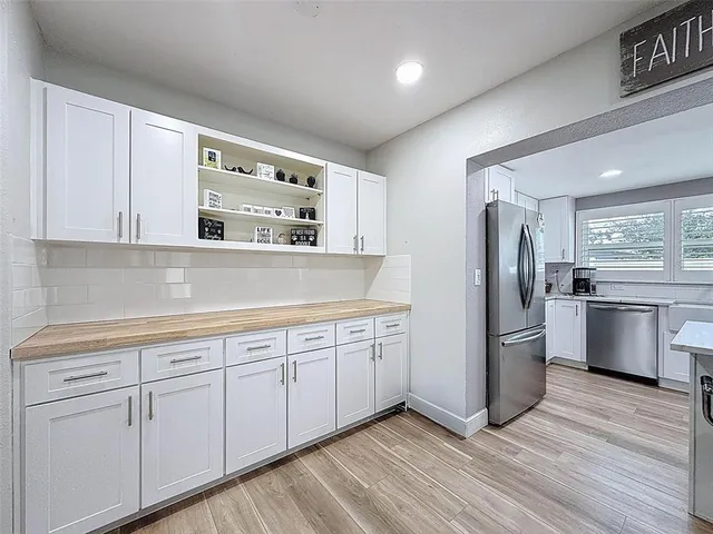 a kitchen with white cabinets and a window