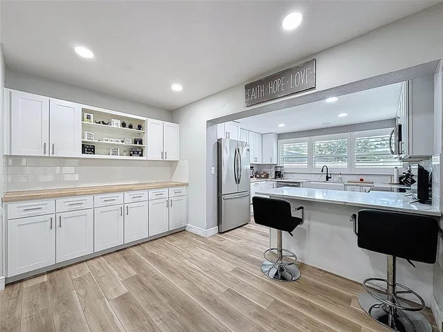 a kitchen with cabinets appliances a sink and a window