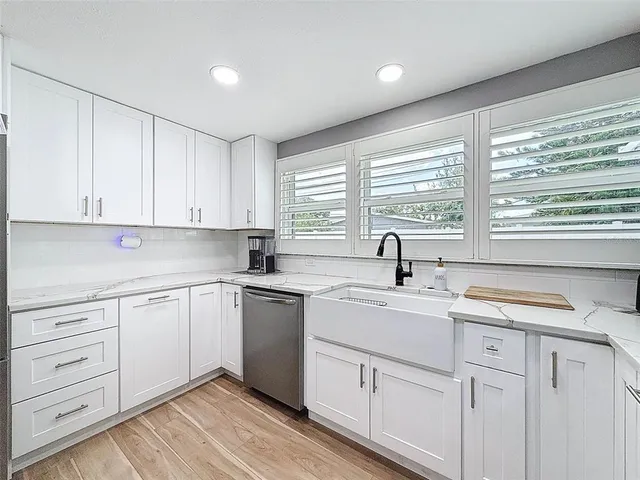 a kitchen with cabinets stainless steel appliances a sink and a window