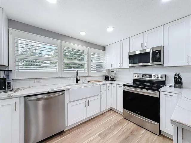 a kitchen with a sink appliances cabinets and furniture