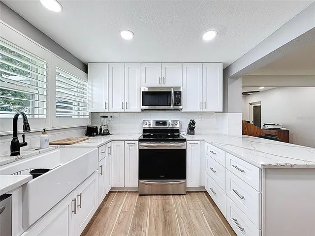 a view of a hallway with wooden floor and a bathroom