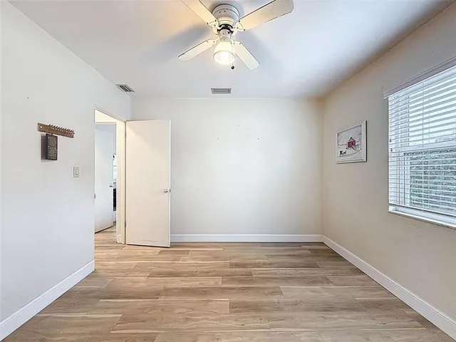 a view of a big room with wooden floor and windows
