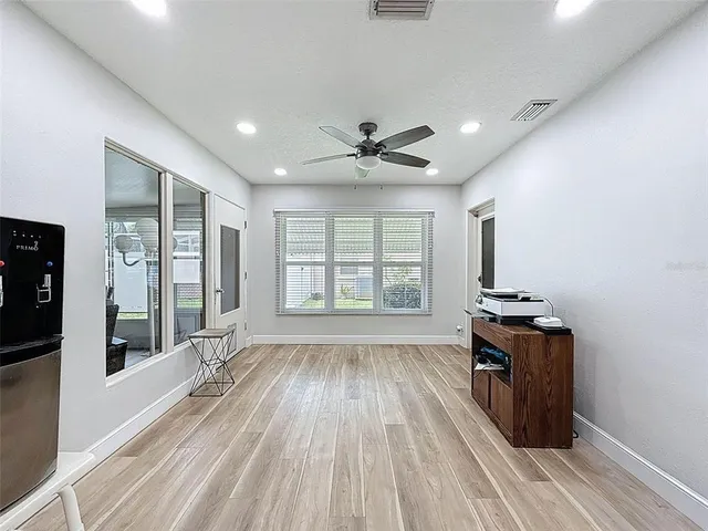 a view of a living room hardwood floor and a ceiling fan