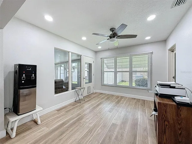 a living room with furniture a flat screen tv and a large window