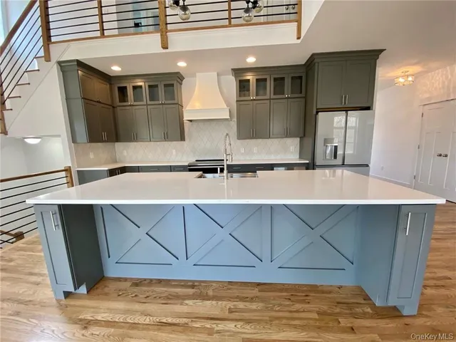 a kitchen with stainless steel appliances granite countertop a sink and a refrigerator