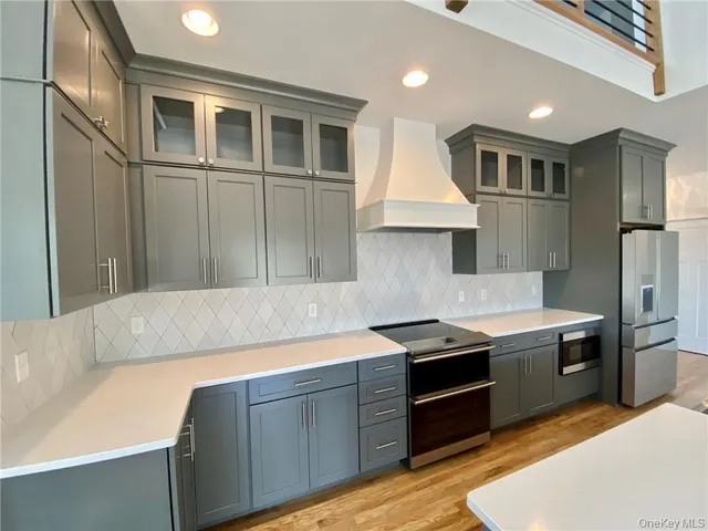 a kitchen with stainless steel appliances granite countertop a refrigerator a sink and a stove