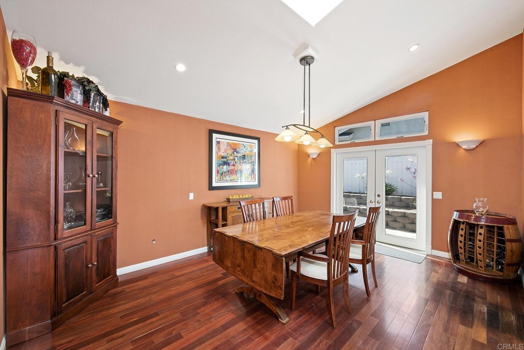 4730 Edinburgh Drive Carlsbad, CA 92010 - Photo 13 of 33 a dining room with wooden floor a chandelier a wooden table and chairs