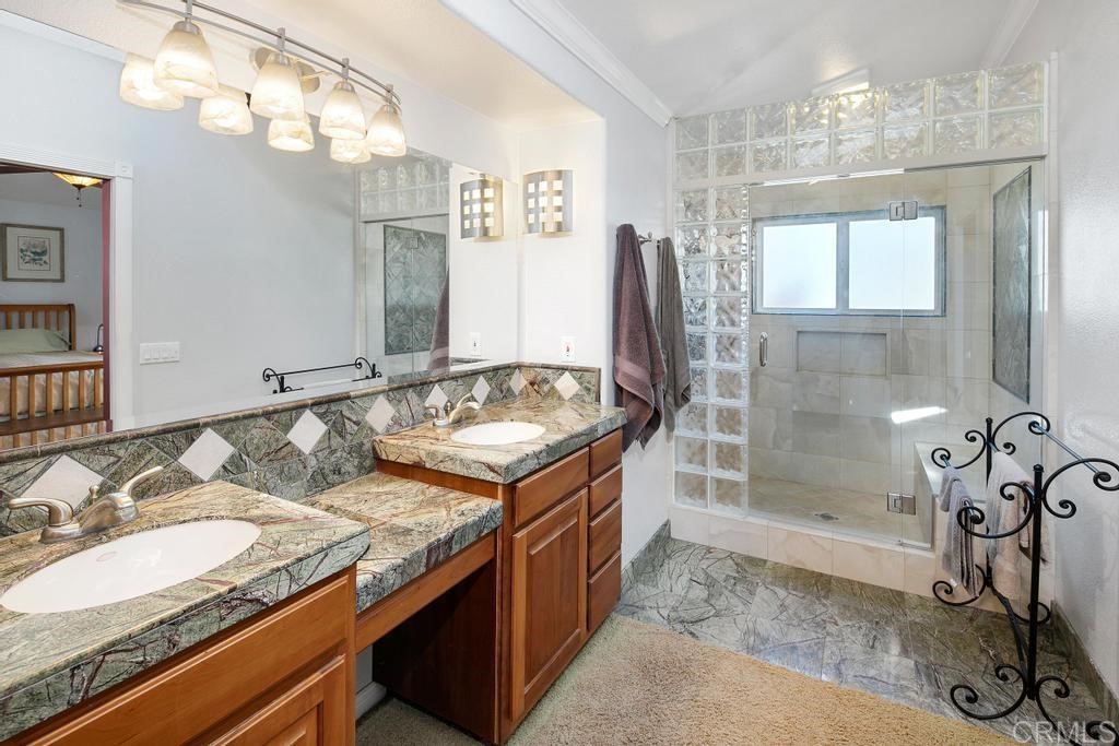 4730 Edinburgh Drive Carlsbad, CA 92010 - Photo 20 of 33 a bathroom with a granite countertop sink a mirror and a shower
