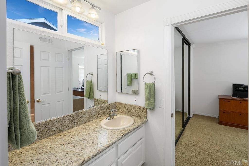 4730 Edinburgh Drive Carlsbad, CA 92010 - Photo 24 of 33 a bathroom with a granite countertop sink and a mirror