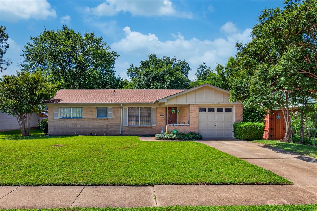 Brick exterior featuring a single-car garage, concrete driveway, and a front porch