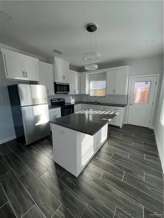 a large kitchen with stainless steel appliances granite countertop a stove a sink dishwasher and a refrigerator