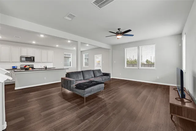 a living room with furniture and a wooden floor
