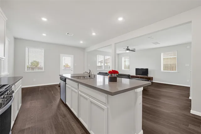 a kitchen with sink stove and wooden floor