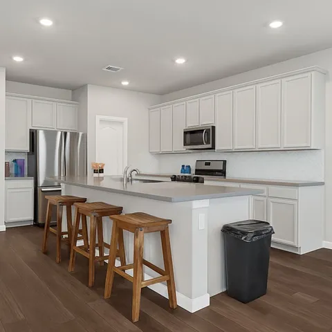 a kitchen with stainless steel appliances granite countertop a refrigerator a stove top oven a sink and dishwasher