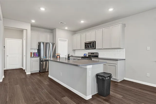 a kitchen with refrigerator cabinets and wooden floor