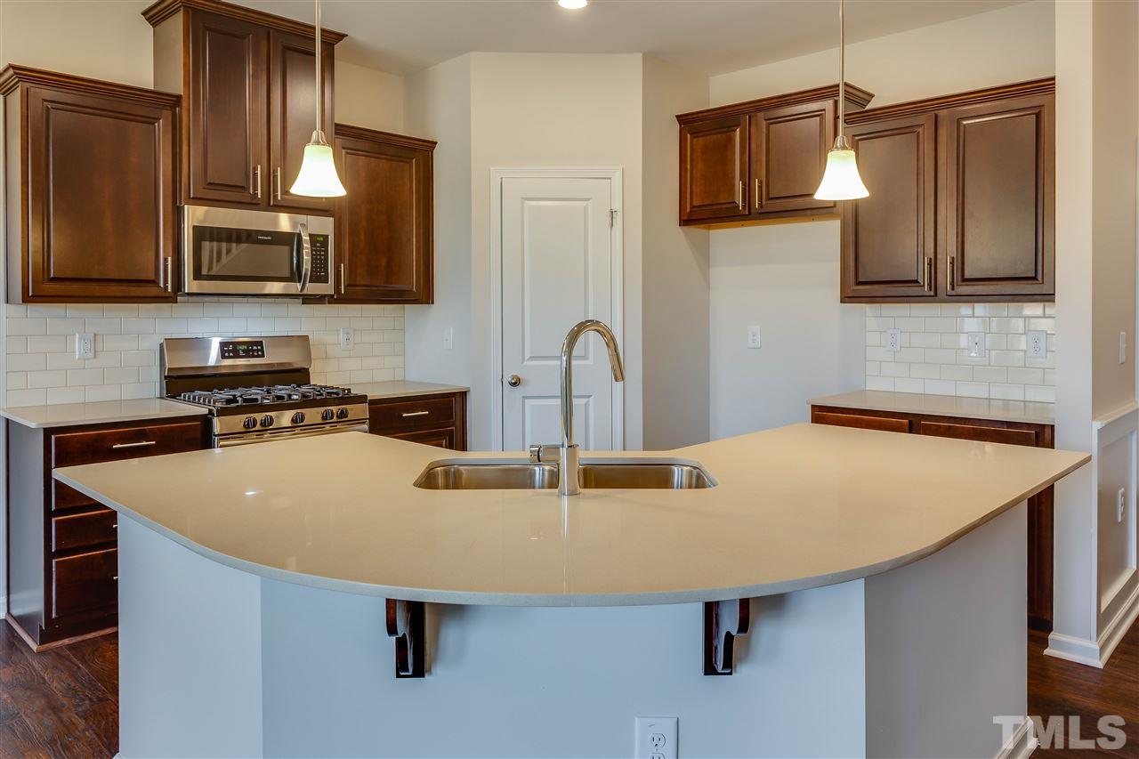 6004 Beale Loop, Unit 125 ABBEY Raleigh, NC 27616 - Photo 4 of 16 a kitchen with stainless steel appliances a sink a microwave a refrigerator and cabinets