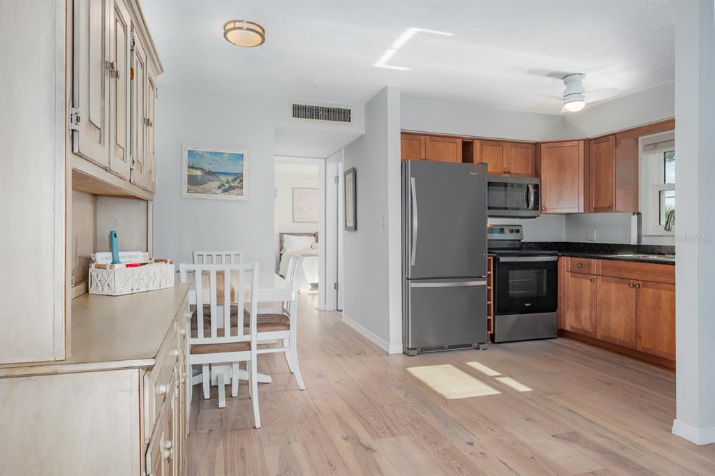 7151 Sunset Way, Unit 10 St. Pete Beach, FL 33706 - Photo 14 of 33 a kitchen with granite countertop a refrigerator stove microwave and cabinets