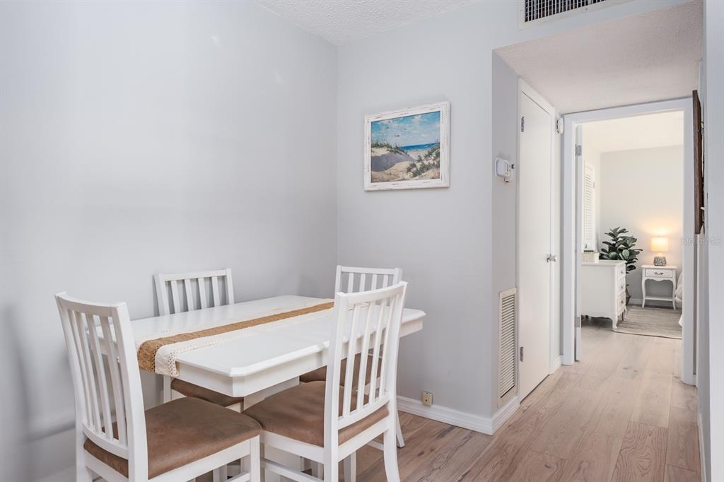 7151 Sunset Way, Unit 10 St. Pete Beach, FL 33706 - Photo 15 of 33 a view of a dining room with furniture and wooden floor