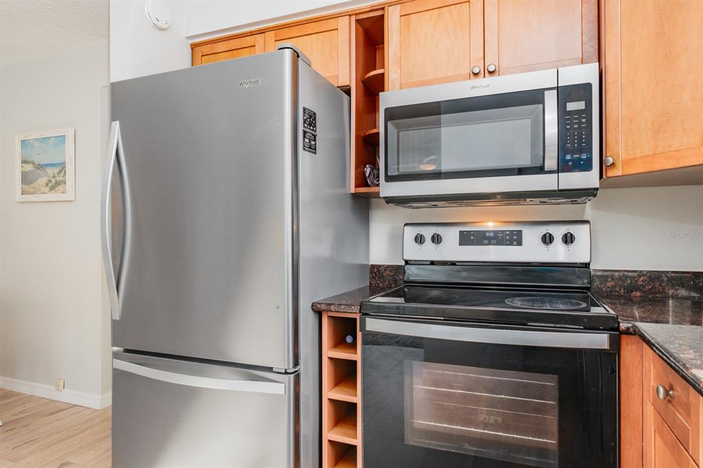 7151 Sunset Way, Unit 10 St. Pete Beach, FL 33706 - Photo 16 of 33 a kitchen with stainless steel appliances a refrigerator stove and microwave