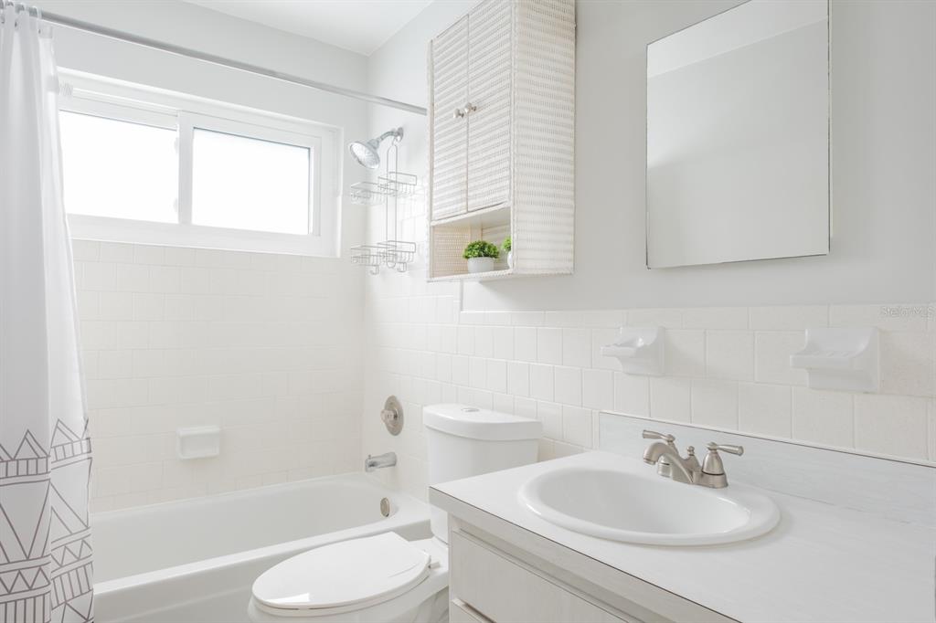 7151 Sunset Way, Unit 10 St. Pete Beach, FL 33706 - Photo 23 of 33 a bathroom with a sink toilet and shower