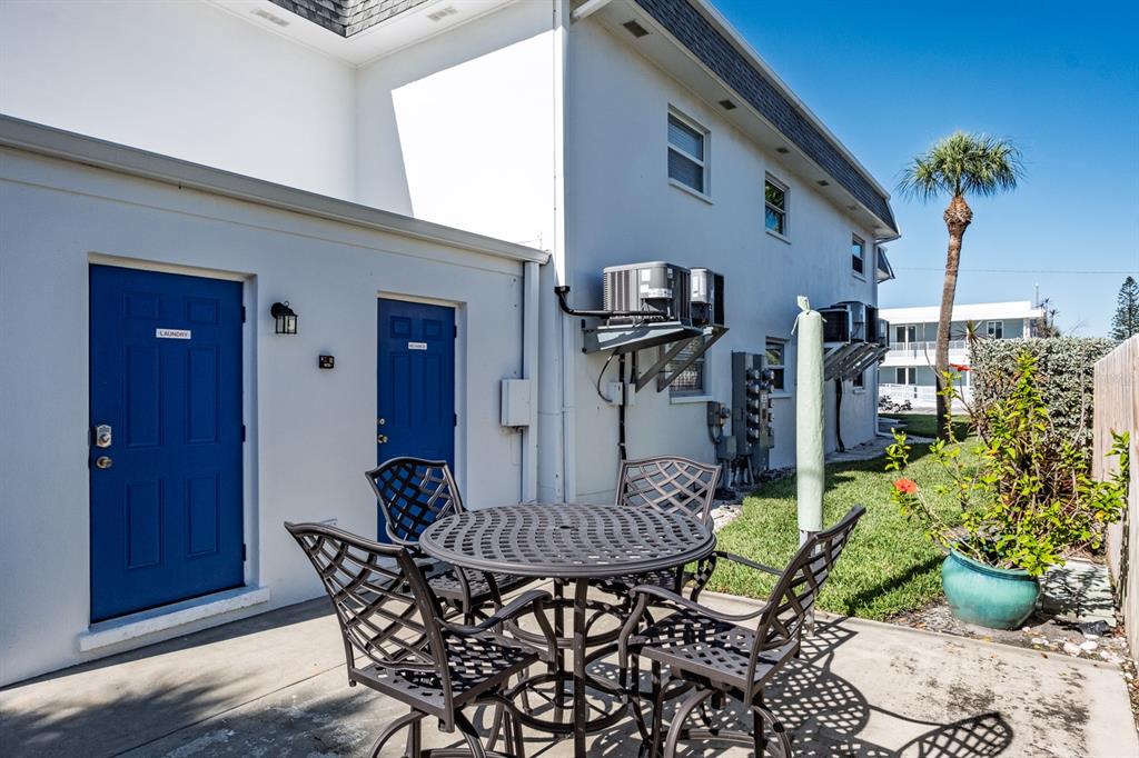7151 Sunset Way, Unit 10 St. Pete Beach, FL 33706 - Photo 24 of 33 a table and chairs in front of a house