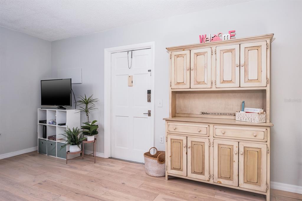7151 Sunset Way, Unit 10 St. Pete Beach, FL 33706 - Photo 6 of 33 a kitchen with stainless steel appliances granite countertop a stove top oven a sink and a microwave with wooden floor