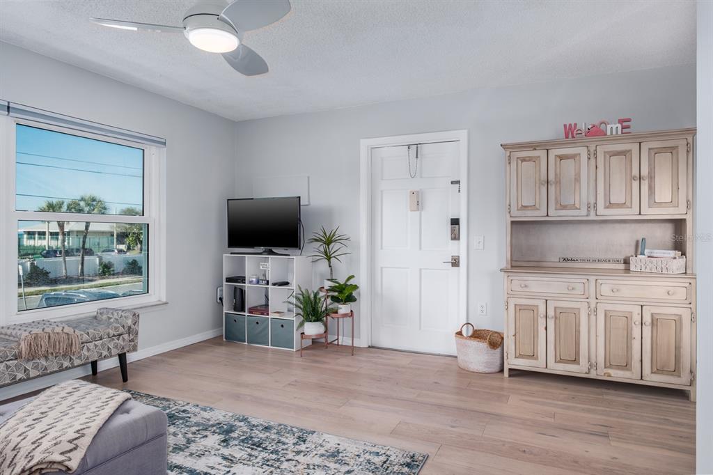 7151 Sunset Way, Unit 10 St. Pete Beach, FL 33706 - Photo 7 of 33 a living room with furniture a flat screen tv and a window