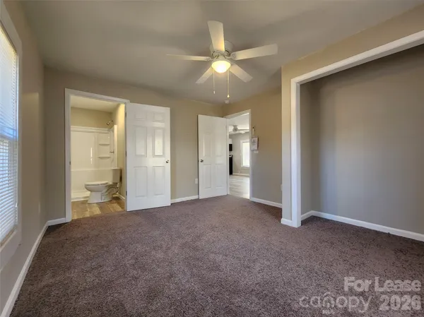 an empty room with fan and entrance