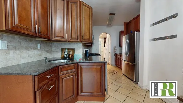 a kitchen with stainless steel appliances granite countertop a refrigerator and a sink