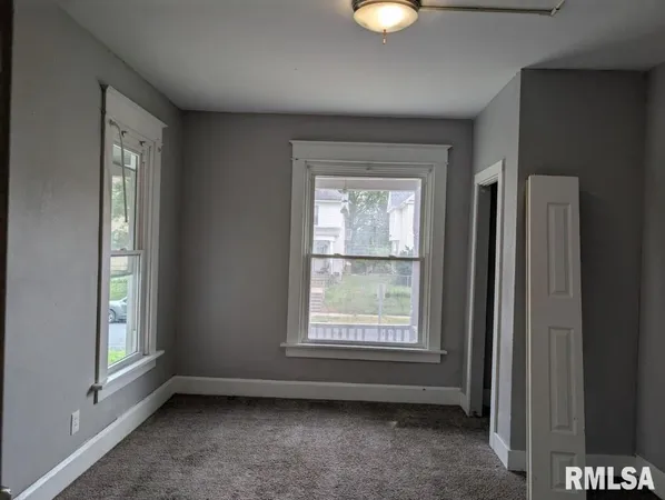 an empty room with windows and closet