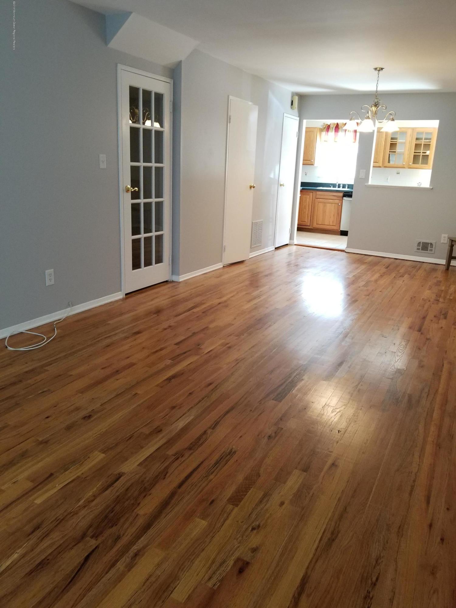 321 Spring Street, Unit 21 Red Bank, NJ 07701 - Photo 4 of 11 an empty room with wooden floor and windows