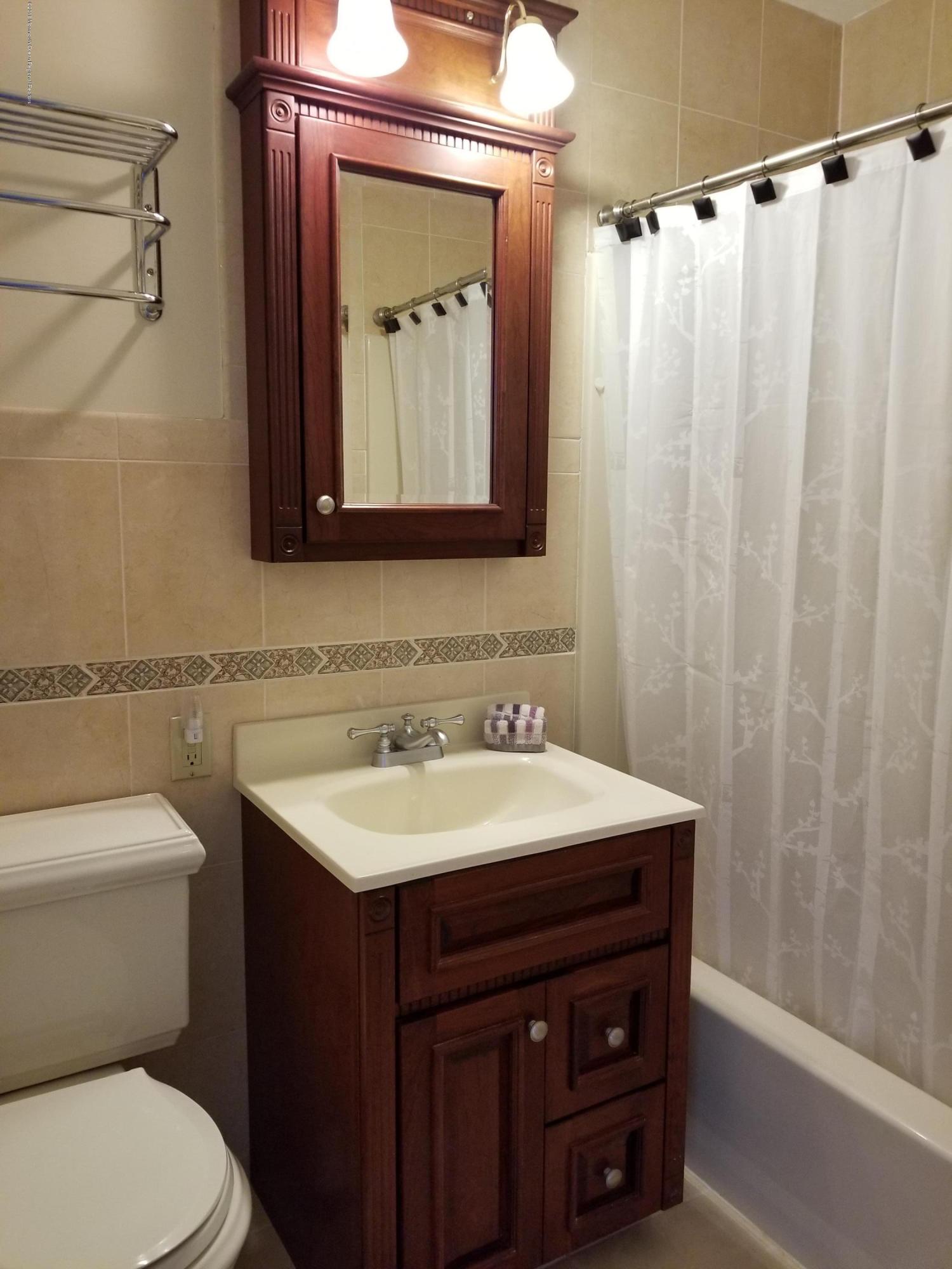 321 Spring Street, Unit 21 Red Bank, NJ 07701 - Photo 5 of 11 a bathroom with a sink vanity mirror and toilet
