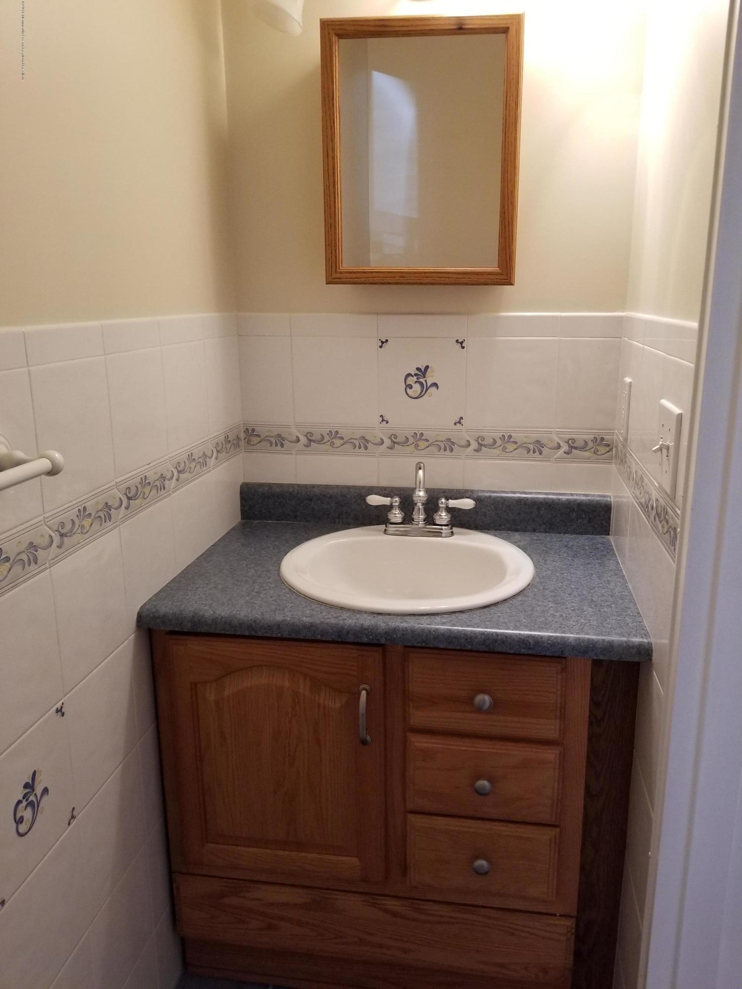 321 Spring Street, Unit 21 Red Bank, NJ 07701 - Photo 7 of 11 a sink sitting under a bathroom mirror