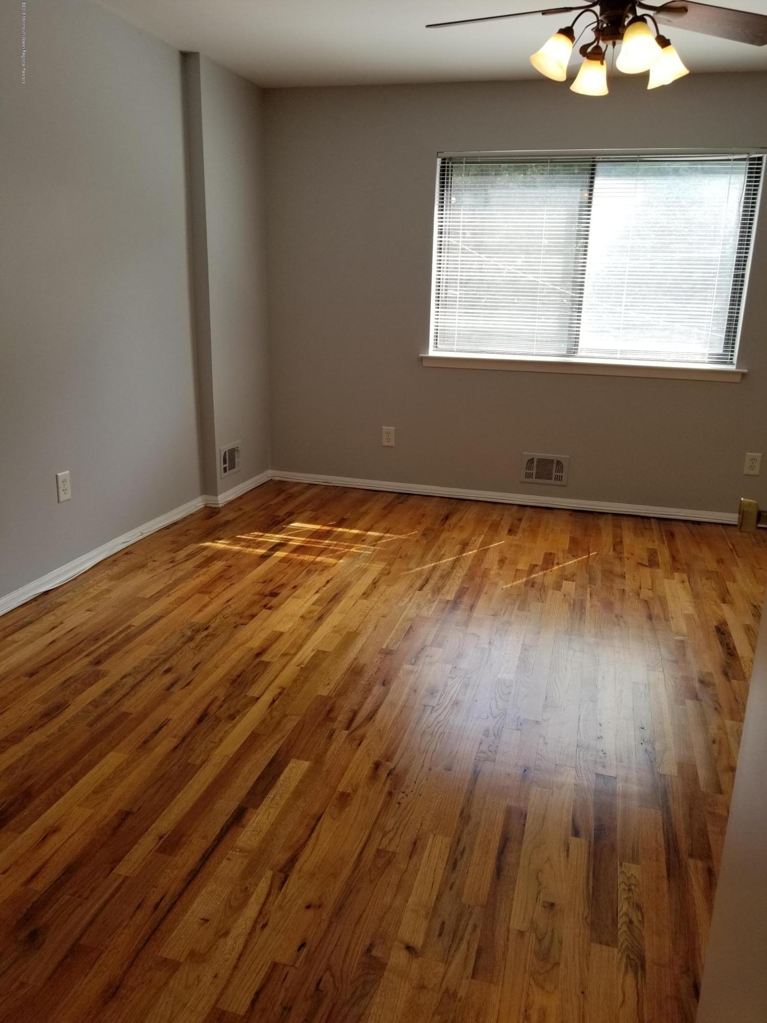 321 Spring Street, Unit 21 Red Bank, NJ 07701 - Photo 8 of 11 wooden floor in an empty room with a window